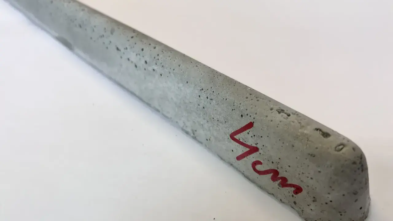 Szary, betonowy element, jeden z dystansów pod zbrojenie, z oznaczeniem "4 cm" na czerwono.