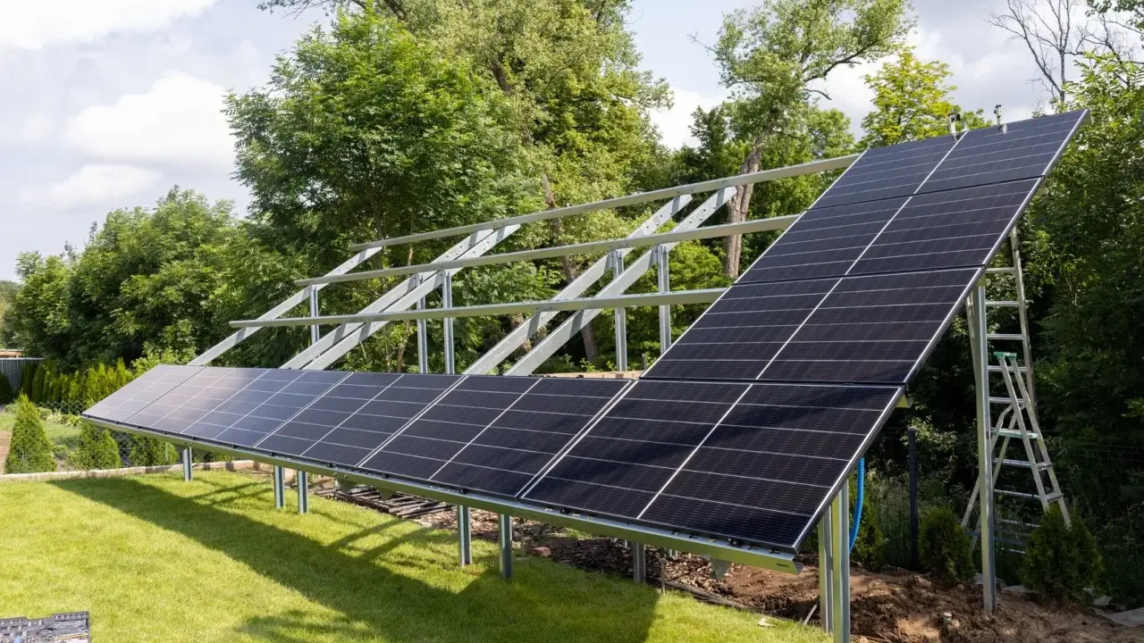 Instalacja PV co to? Panele słoneczne montowane na konstrukcji w ogrodzie, gotowe do produkcji czystej energii.