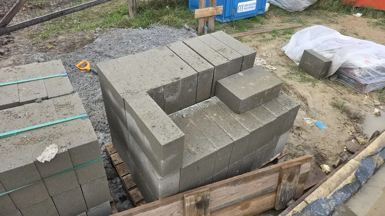 Rozpoczęto murowanie z bloczków betonowych. Układane są pierwsze warstwy, tworząc zarys przyszłej konstrukcji.