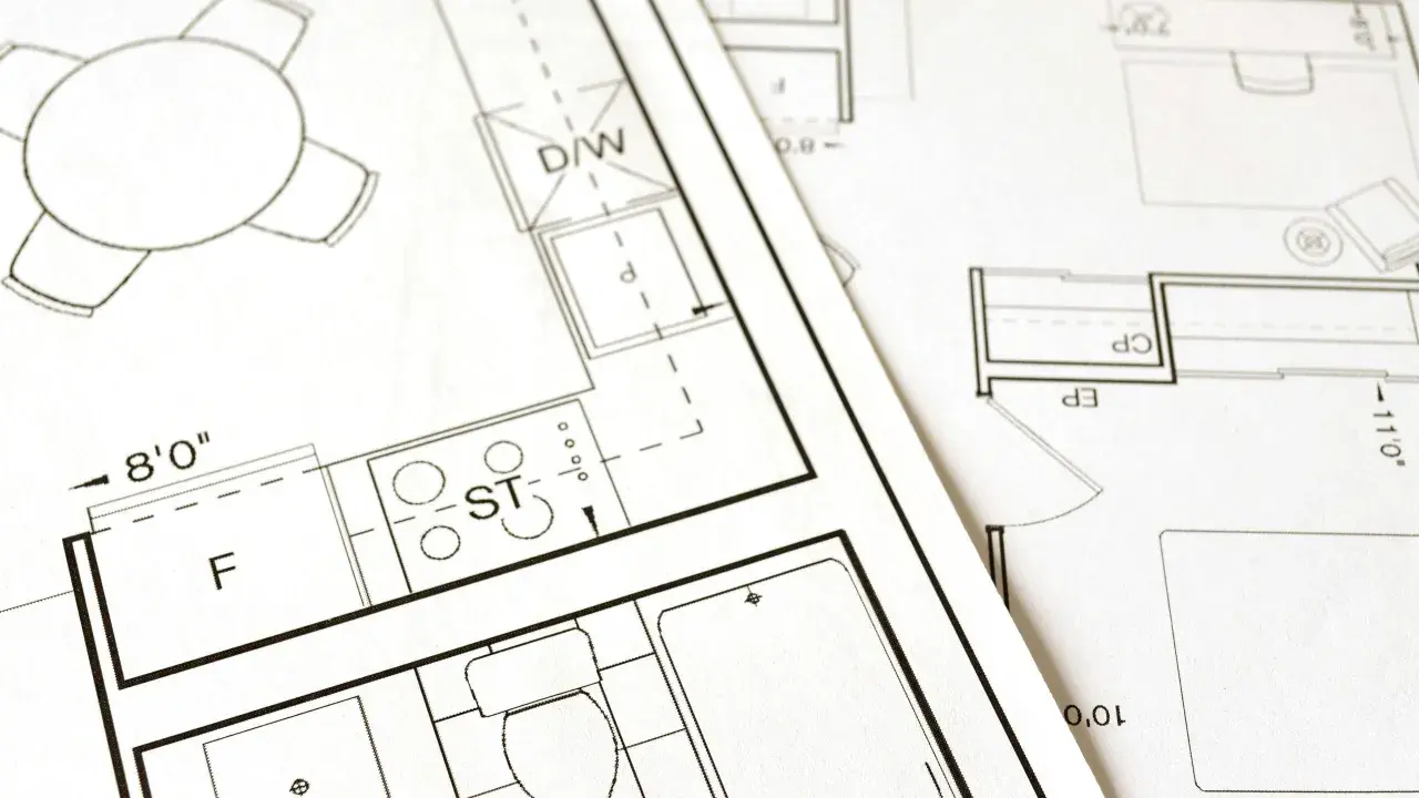 Plany architektoniczne z kuchnią, łazienką i stołem. Kluczowe etapy: warunki zabudowy a pozwolenie na budowę.