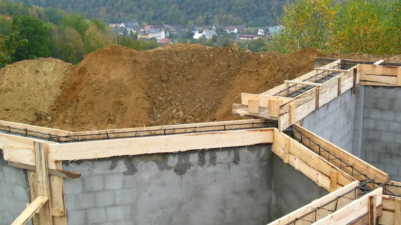 Fundamenty domu w budowie, zbrojenie i szalunki czekają na beton. Ważne jest pozwolenie na budowę, by wszystko szło zgodnie z planem.