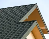 Dwa dachy z ciemnozielonej blachodachówki, z żółtymi szczytami. Może to być odstępstwo od odległości od granicy działki.
