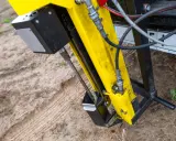 Żółta maszyna do badań geotechnicznych gruntu w akcji. Wiertło zagłębia się w ziemię, zbierając próbki do analizy.