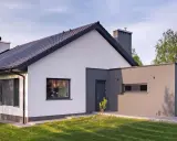 Nowoczesny dom z białymi i grafitowymi akcentami. Eleganckie kolory elewacji domu podkreślają jego architekturę.