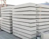 Stos prefabrykatów betonowych, gotowych do budowy domu z prefabrykatów betonowych.