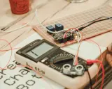 Multimetr i płytka stykowa z modułem przekaźników, gotowe do odbioru instalacji elektrycznej.