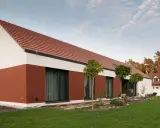 Nowoczesny dom z ceglanym cokołem i białym tynkiem. Ciekawe połączenie kolorów tynków na domach tworzy harmonijną całość.