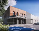 Nowoczesny budynek biurowy projekt z drewnianą elewacją i betonem. Przed budynkiem parking z miejscem dla niepełnosprawnych.