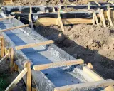 Budowa fundamentów krok po kroku: betonowanie ław fundamentowych w szalunkach z folią.