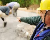 Budowlaniec w żółtym kasku wskazuje kierunek pracy. Co to za chudziak?