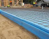 Styrodur pod płytę fundamentową ułożony na piasku, z siatką zbrojeniową gotową do zalania betonem.
