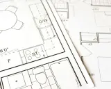 Plany architektoniczne z kuchnią, łazienką i stołem. Kluczowe etapy: warunki zabudowy a pozwolenie na budowę.