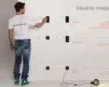 Mężczyzna pokazuje idealne rozmieszczenie puszek elektrycznych na różnych wysokościach: 150 cm, 110-120 cm i 30 cm.