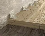Wzmocnienie stropu od góry: drewniane belki połączone z betonową ścianą metalowymi kątownikami i licznymi wkrętami.