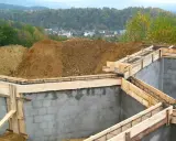 Fundamenty domu w budowie, zbrojenie i szalunki czekają na beton. Ważne jest pozwolenie na budowę, by wszystko szło zgodnie z planem.