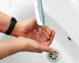Dłonie pod bieżącą wodą z kranu. Zastanawiasz się, jak zwiększyć ciśnienie wody? Sprawdź nasze porady!