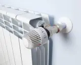 Biały grzejnik z termostatem. Idealne rozwiązanie, jeśli zastanawiasz się, jakie ogrzewanie do domu 70m2 wybrać.