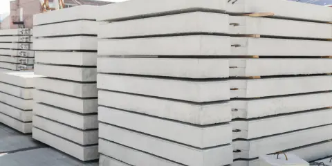 Stos prefabrykatów betonowych, gotowych do budowy domu z prefabrykatów betonowych.