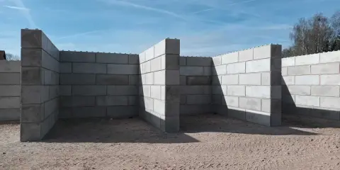 Budowa trwa. Solidny mur z bloczków betonowych tworzy zarys przyszłego obiektu.