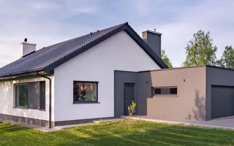Nowoczesny dom z białymi i grafitowymi akcentami. Eleganckie kolory elewacji domu podkreślają jego architekturę.