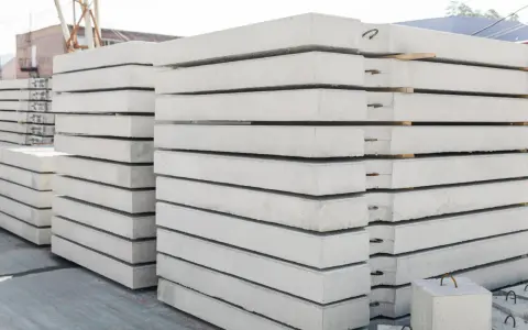 Stos prefabrykatów betonowych, gotowych do budowy domu z prefabrykatów betonowych.