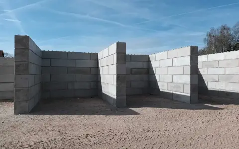 Budowa trwa. Solidny mur z bloczków betonowych tworzy zarys przyszłego obiektu.