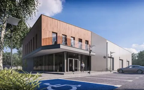 Nowoczesny budynek biurowy projekt z drewnianą elewacją i betonem. Przed budynkiem parking z miejscem dla niepełnosprawnych.