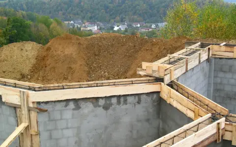 Fundamenty domu w budowie, zbrojenie i szalunki czekają na beton. Ważne jest pozwolenie na budowę, by wszystko szło zgodnie z planem.