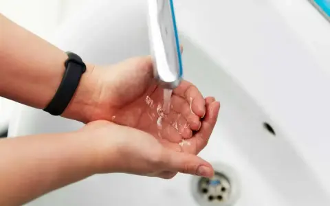Dłonie pod bieżącą wodą z kranu. Zastanawiasz się, jak zwiększyć ciśnienie wody? Sprawdź nasze porady!