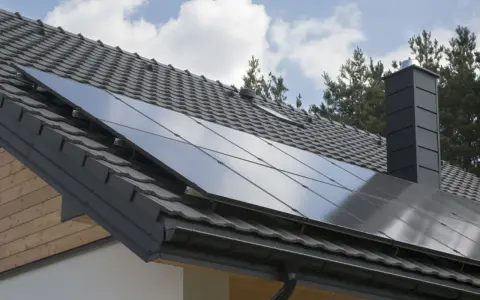 Nowoczesny dach z paneli fotowoltaicznych, szary komin i dachówka. Dom gotowy na zieloną energię.