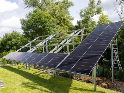 Instalacja PV co to? Panele słoneczne montowane na konstrukcji w ogrodzie, gotowe do produkcji czystej energii.