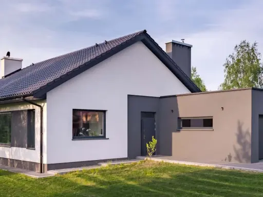 Nowoczesny dom z białymi i grafitowymi akcentami. Eleganckie kolory elewacji domu podkreślają jego architekturę.