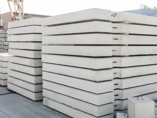 Stos prefabrykatów betonowych, gotowych do budowy domu z prefabrykatów betonowych.
