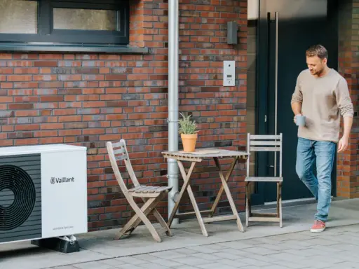 Mężczyzna wychodzi z domu obok pompy ciepła Vaillant. Jaka pompa ciepła zapewni komfort i oszczędność?