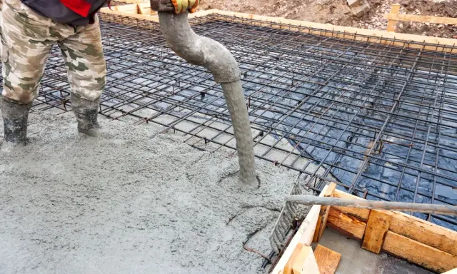Wylewanie betonu na zbrojenie fundamentów. Właściwy beton na fundament to klucz do trwałej budowy.