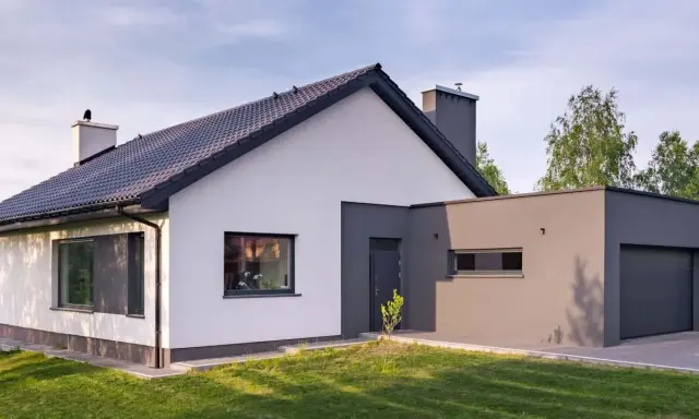 Nowoczesny dom z białymi i grafitowymi akcentami. Eleganckie kolory elewacji domu podkreślają jego architekturę.