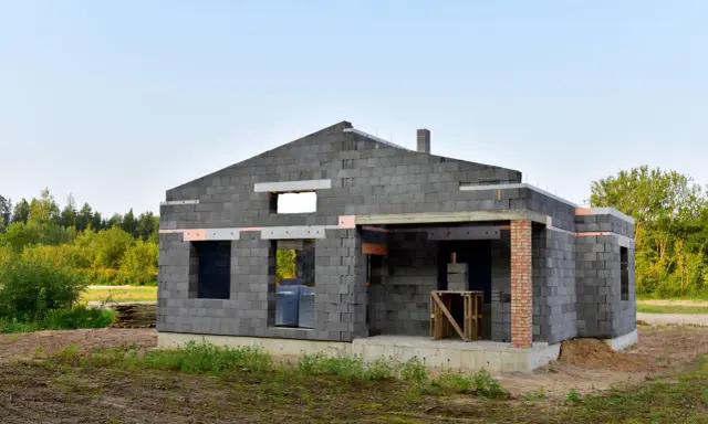 Budowa domu z keramzytu. Brak okien, drzwi i dachu. Widać niedociągnięcia, które mogą być wadami.