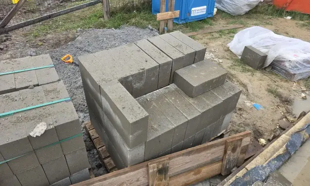 Rozpoczęto murowanie z bloczków betonowych. Układane są pierwsze warstwy, tworząc zarys przyszłej konstrukcji.