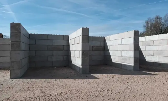 Budowa trwa. Solidny mur z bloczków betonowych tworzy zarys przyszłego obiektu.
