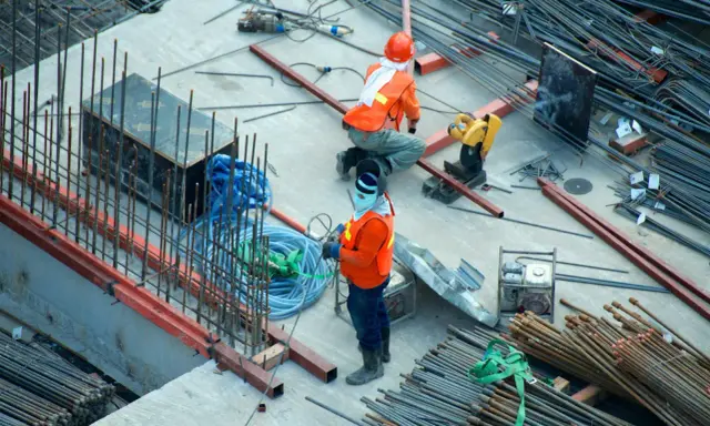 Budowa domu to proces, który wymaga czasu i pracy. Na placu budowy widać robotników i materiały.