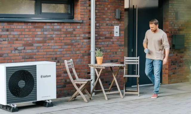 Mężczyzna wychodzi z domu obok pompy ciepła Vaillant. Jaka pompa ciepła zapewni komfort i oszczędność?