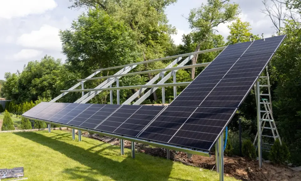 Instalacja PV co to? Panele słoneczne montowane na konstrukcji w ogrodzie, gotowe do produkcji czystej energii.