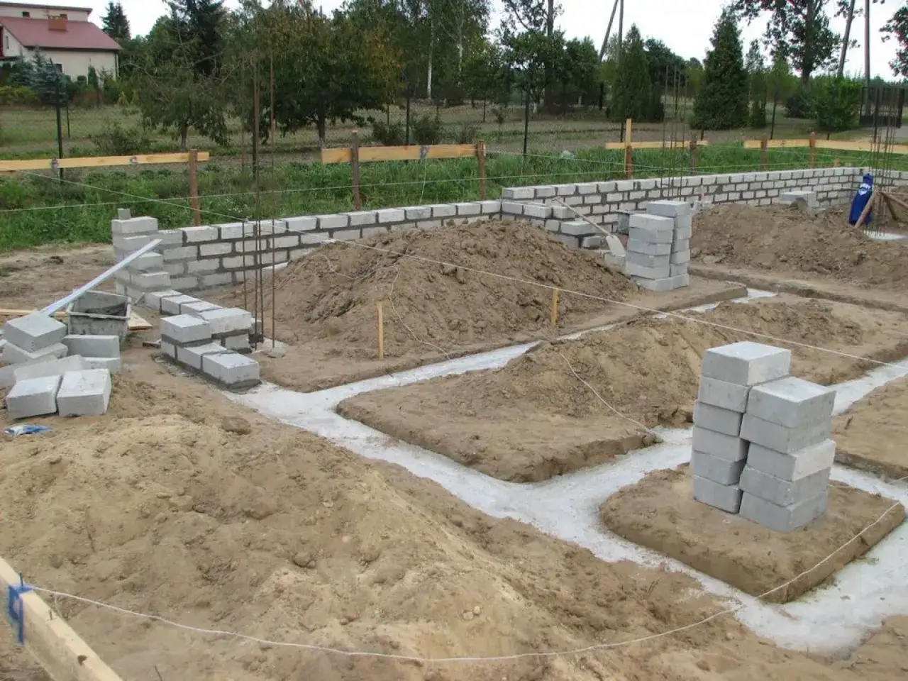 Budowa domu murowanego 70m2. Fundamenty i pierwsze warstwy ścian z bloczków betonowych.