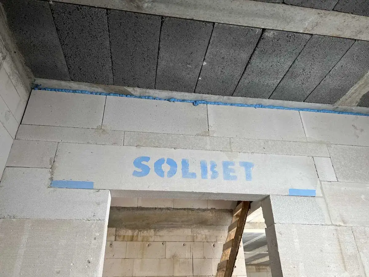 Dylatacja co to? Pianka montażowa między blokami betonu komórkowego a stropem. Widoczny napis