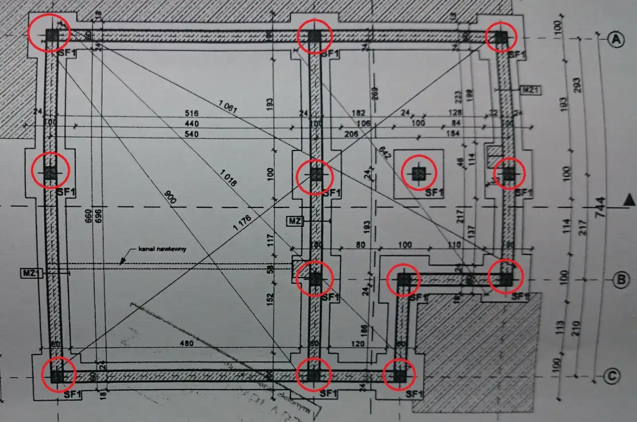 Plan budowlany z zaznaczonymi czerwonymi okręgami słupami betonowymi konstrukcyjnymi.
