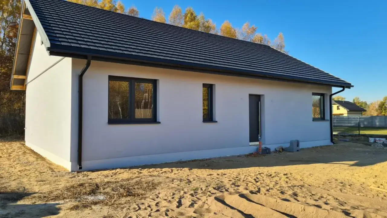 Dom w stanie surowym zamkniętym, z oknami i drzwiami, gotowy do prac wykończeniowych, by stać się stanem deweloperskim.