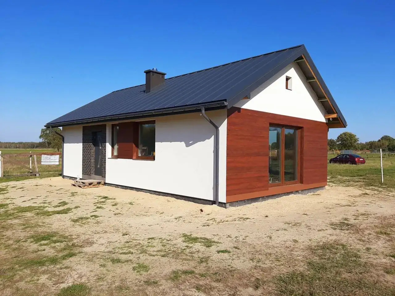 Nowy, nowoczesny dom bez pozwolenia 100m2 z drewnianą elewacją i czarnym dachem, gotowy do zamieszkania.